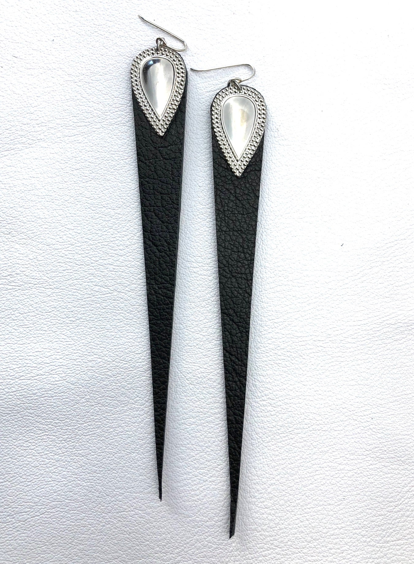 Dramatic length, leather drops.