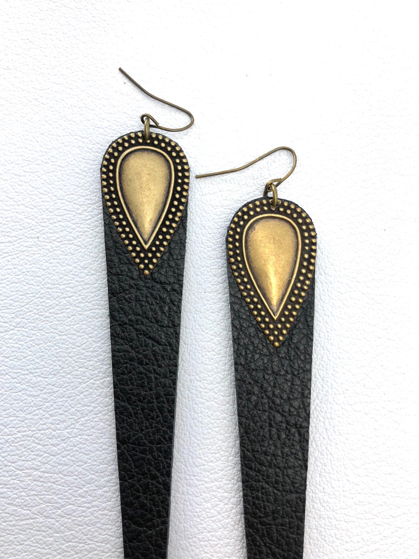 Dramatic length, leather drops.